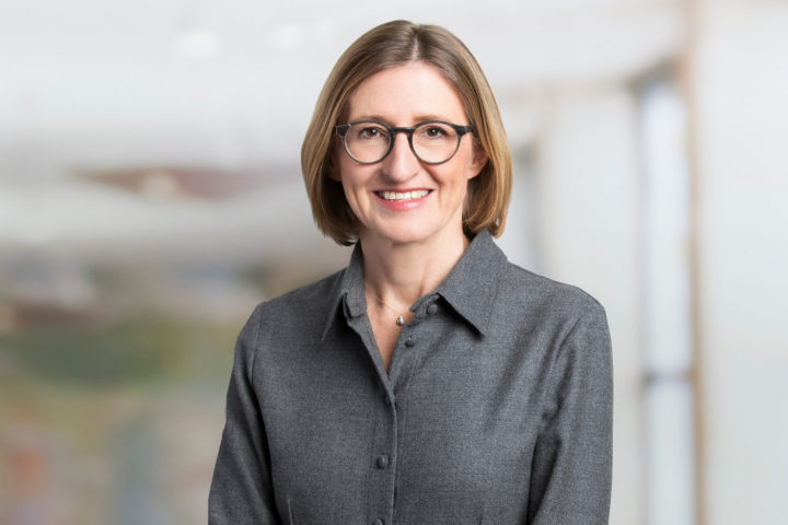 A person wearing glasses and a grey shirt Description automatically generated