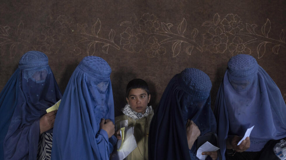 Des femmes afghanes attendent de recevoir de l'argent dans un point de distribution d'argent organisé par le Programme alimentaire mondial, à Kaboul, en Afghanistan, le 20 novembre 2021.