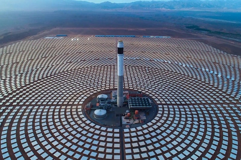 A large solar panel array with a tower in the middle

AI-generated content may be incorrect.